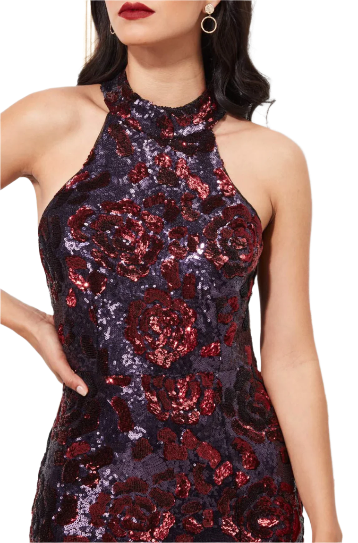 Woman wearing a sequin dress with floral patterns against a white wall.